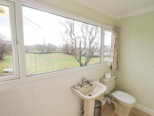 a bathroom with a sink and a toilet and a window at Crag View in Underbarrow