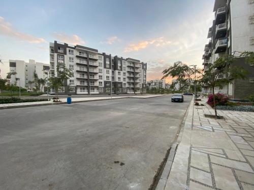 an empty street with a car driving down a street at Luxury Inn: 3BR Amazing View in Madinaty12 in Madinaty