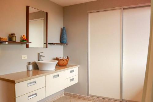 a bathroom with a sink and a glass shower stall at Villa La Vista of Panama City and magestical mountains from infinity pool in Cerro Azul