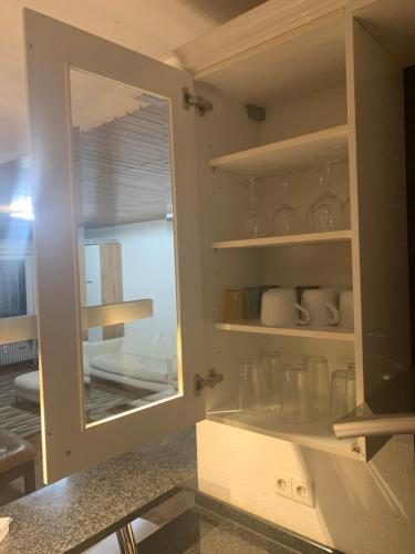 a kitchen with a cabinet with a mirror and a window at Apartment Heinrich mit Ausstellung E-Rechnung in Heddesheim