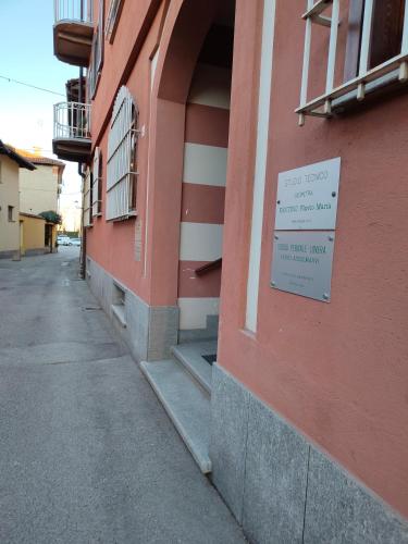 a red building with a sign on the side of it at Il Tarassaco in Busca