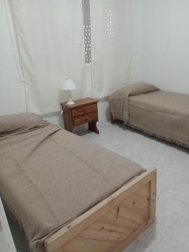 1 dormitorio con 2 camas y mesita de noche en Depto 21 en Miramar