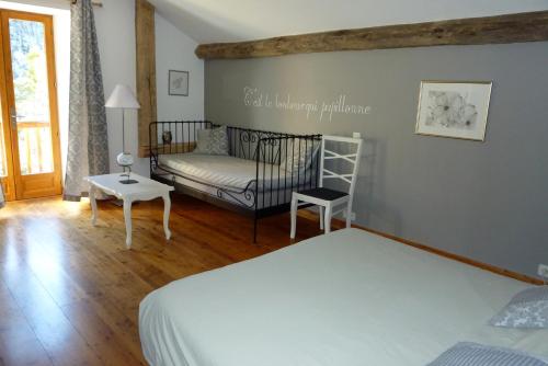 1 dormitorio con 1 cama y 1 sofá en Le Moulin Ollivier en Saint-André-dʼEmbrun