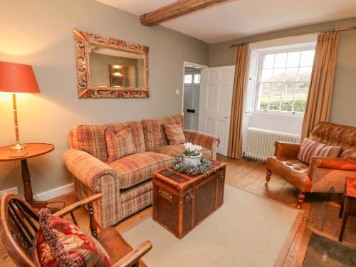 ein Wohnzimmer mit einem Sofa und einem Tisch in der Unterkunft Church Cottage in Bakewell