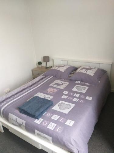 um quarto com uma cama com um edredão roxo em Appartement Rosendael proximité plage Malo les bains em Dunkerque