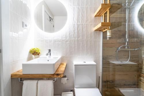 uma casa de banho com um lavatório, um WC e um espelho. em Casas Casal Do Carvalhal - Agroturismo em Amares