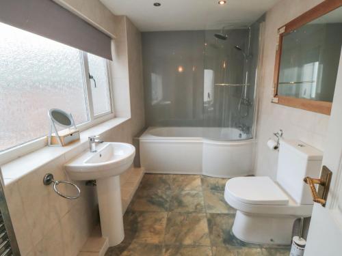 a bathroom with a sink and a toilet and a tub at Smoked Kipper Cottage in Whitby