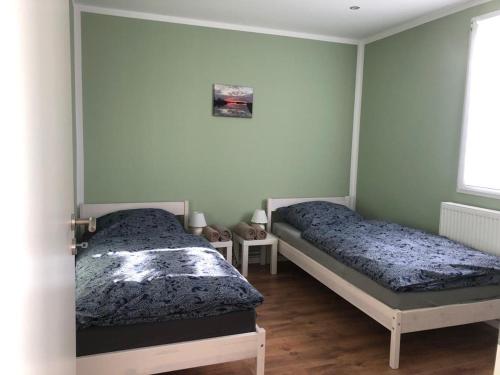 two beds sitting in a room with green walls at Naturheilcamp Götzer Berge in Groß Kreutz