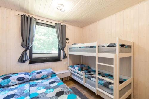 a bedroom with two bunk beds and a window at Holiday homes with fireplaces, Jaroslawiec in Jarosławiec