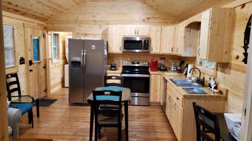 セバービルにあるSmoky Hollow Outdoor Resort - Log Cabinのキッチン(ステンレス製の冷蔵庫、木製キャビネット付)