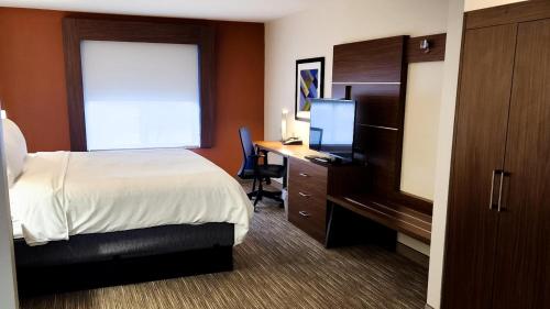 ein Hotelzimmer mit einem Bett und einem Schreibtisch mit einem Computer in der Unterkunft Holiday Inn Express Hotel & Suites Chicago South Lansing, an IHG Hotel in Lansing