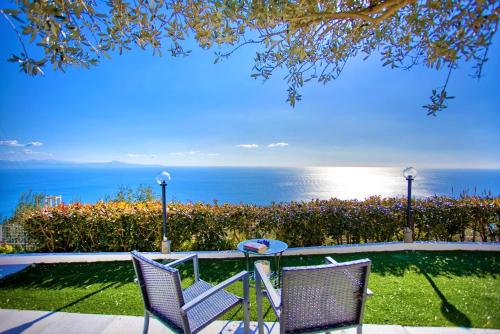 two chairs sitting on a patio overlooking the ocean at Il Giardino di Rosa in Amalfi