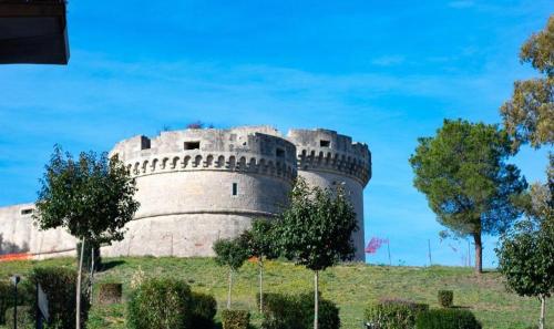 a castle on a hill with trees in front of it at M&G holiday house in Matera