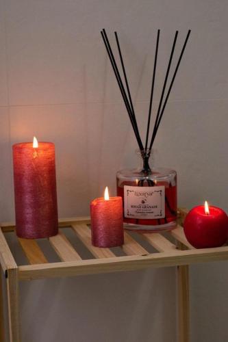 three candles sitting on a shelf next to a jar of candlesearcher at M&G holiday house in Matera
