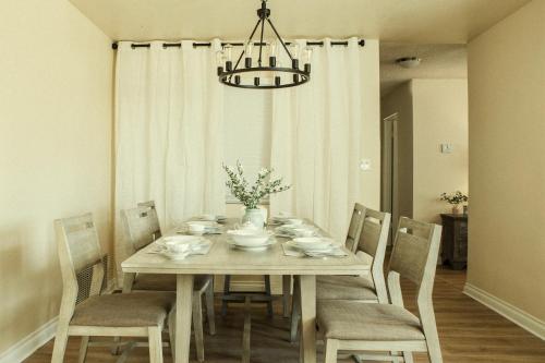 a dining room table with chairs and a chandelier at Cozy Family Home - 20 Mins from Disneyland in Placentia