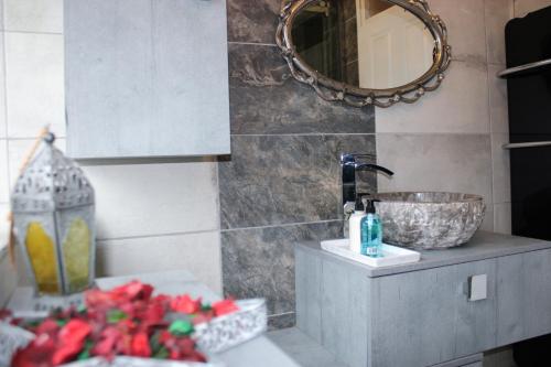 een badkamer met een wastafel en een spiegel bij Stylish 4-Bedroom House near NEC/BHX in Solihull