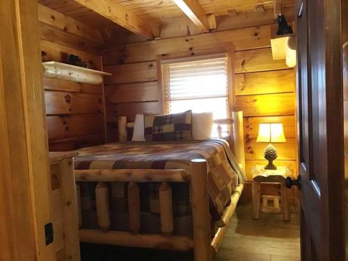 a bedroom with a bed in a log cabin at Dollywood-Brand New Dancing Bear 4 in Pigeon Forge