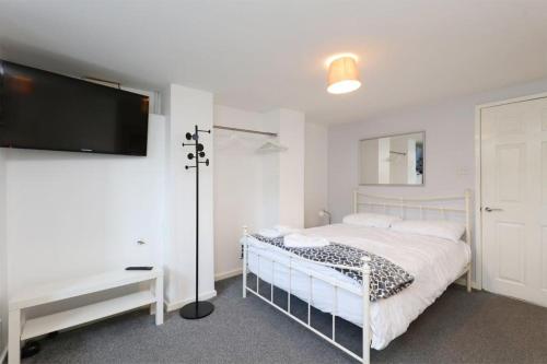 a bedroom with a bed and a flat screen tv at Spacious 2 Bed, Free Parking, Free Wifi - Serene Homes Sheffield in Hillsborough