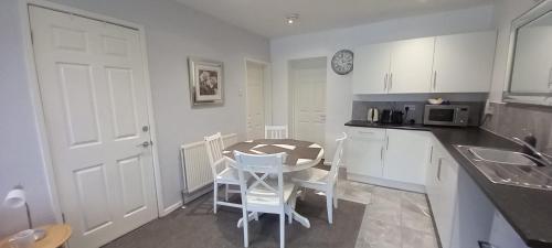 uma cozinha com uma mesa e cadeiras numa cozinha em Spacious 2 Bed, Free Parking, Free Wifi - Serene Homes Sheffield em Hillsborough