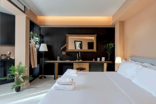 a bedroom with a large white bed and a desk at Clyde Athens by Nin&Bau in Athens