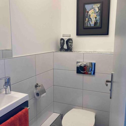 une salle de bain blanche avec des toilettes et un lavabo dans l'établissement Appartement standing vue Mer, à Trouville-sur-Mer