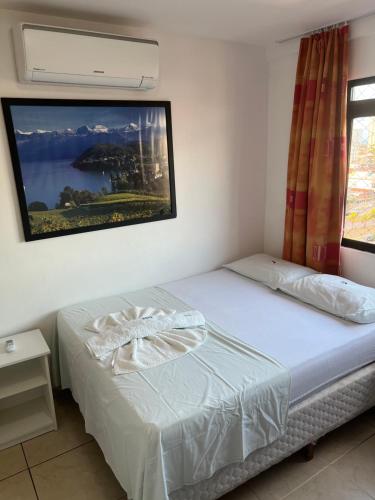 1 dormitorio con 1 cama con una foto en la pared en Beautiful flat Ponta Negra sem custos adicionais!, en Natal