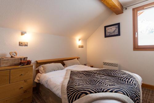 a bedroom with a zebra print bed and a window at Lagrange Vacances Les Balcons des Aiguilles in La Toussuire