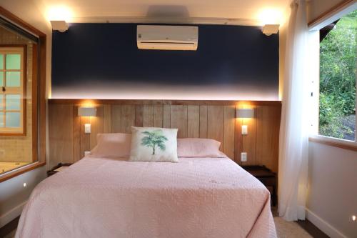 a bedroom with a large bed with a white blanket at Auberge Suisse Pousada in Nova Friburgo