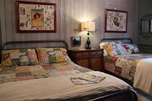 um quarto com 2 camas e uma mesa com um candeeiro em Acorn Hideaways Canton Beautiful 1890s Fashion Suite up to 6 em Canton