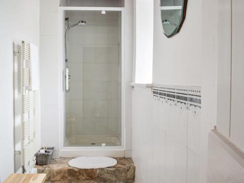 a white bathroom with a shower and a toilet at The End Hoose in Whitsome