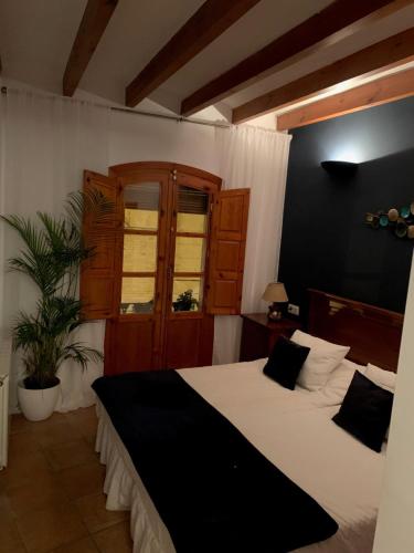 una camera con due letti con lenzuola bianche di Las Puertas Del Indiano a Relleu