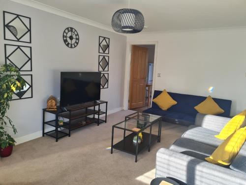 a living room with a couch and a tv at The Appleleaf with Free Parking in Barton-upon-Humber