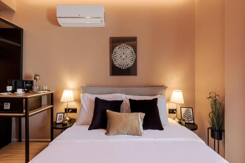 a bedroom with a bed and a desk with two lamps at Clyde Athens by Nin&Bau in Athens
