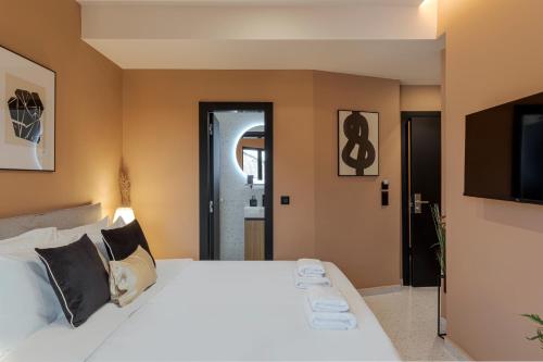a bedroom with a large white bed and a flat screen tv at Clyde Athens by Nin&Bau in Athens