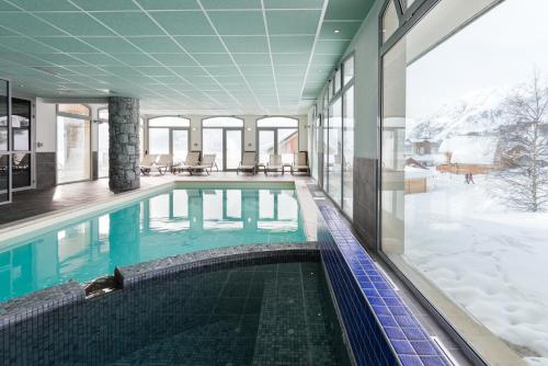 une piscine au milieu d'un immeuble dans l'établissement Lagrange Vacances Les Balcons des Aiguilles, à La Toussuire
