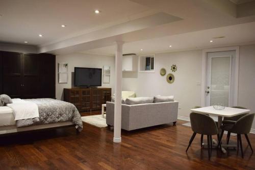 a bedroom with a bed and a couch and a table at Home Away From Home - Basement Studio Apartment in Toronto