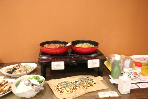 a table with two bowls of food on a stove at Urbain Hiroshima Central in Hiroshima