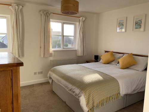 a bedroom with a bed and two windows at Newly Renovated 2 Bed house nr Fistral Beach & Gannel Estuary in Newquay