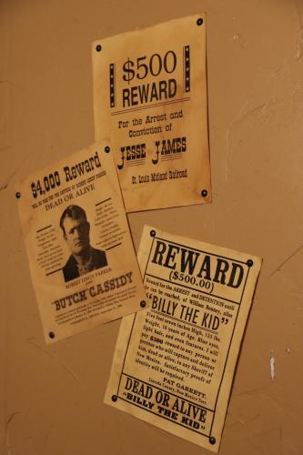 a bunch of posters on a wall at Acorn Hideaways Canton Rustic Old West Frontier Suite in Canton