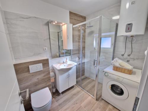 a bathroom with a shower sink and a washing machine at Apartments Duje in Split
