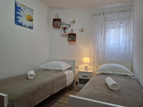 a bedroom with two beds and a table with a lamp at Apartments Duje in Split