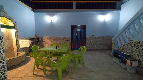 a room with a table and chairs and a staircase at Casa Morisca in Sidi Ifni