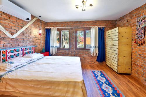 a bedroom with a large bed and a brick wall at Kalkan - 2+1 - Full Sea View - Shavilla Han in Patara