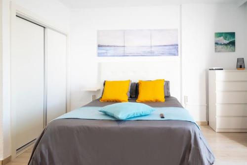 a bedroom with a bed with two yellow pillows at Las Americas studio in Playa de las Americas
