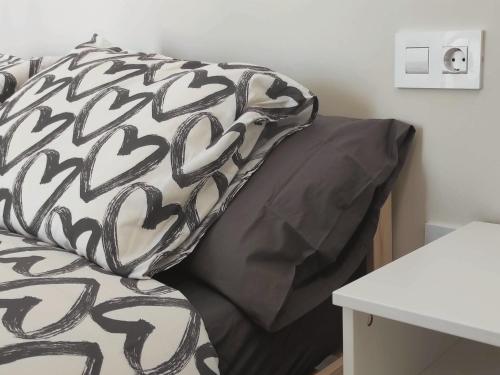 cuscino bianco e nero su un letto in una stanza di Apartamentos Carrillo 4 Ático a Santa Cruz de Tenerife