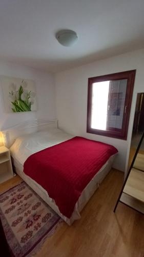 una camera da letto con un letto grande con una coperta rossa di Bjelasica Home a Kolašin