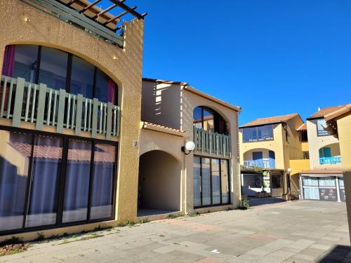 - un bâtiment avec de grandes fenêtres et un parking dans l'établissement T3 vue superbe à 5 mns de la plage avec wifi parking gratuit, au Barcarès