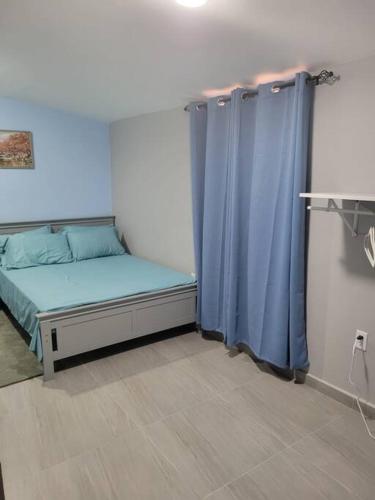 um quarto com uma cama e uma cortina azul em Cozy 1-bedroom apartment close to city center em Willemstad