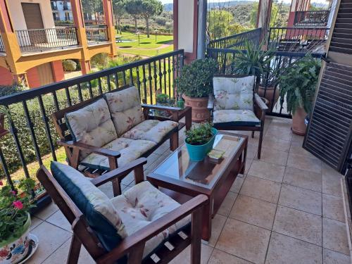 a patio with two chairs and a table on a balcony at APARTAMENTO MANUELA PROXIMO a GOLF ISLA CANELA LINKS in Ayamonte