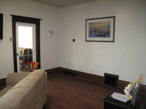 a living room with a couch and a picture on the wall at Wolseley the heart of the city ! in Winnipeg